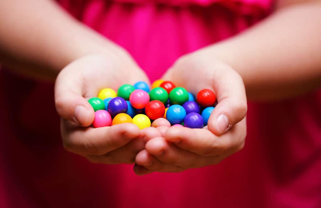 Girl is holding out her hands to share candy