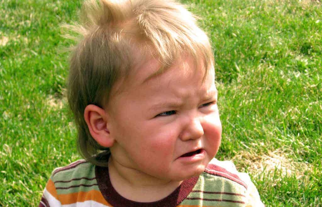Infant boy crying upset on grass