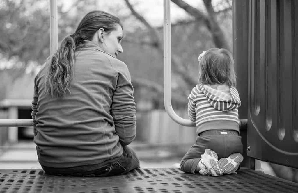 Black and white photo of Mother and toddler talking at playground