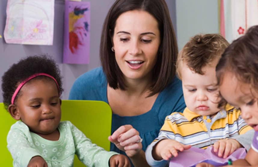 Preschool teacher working with african american toddler, little boy, and girl
