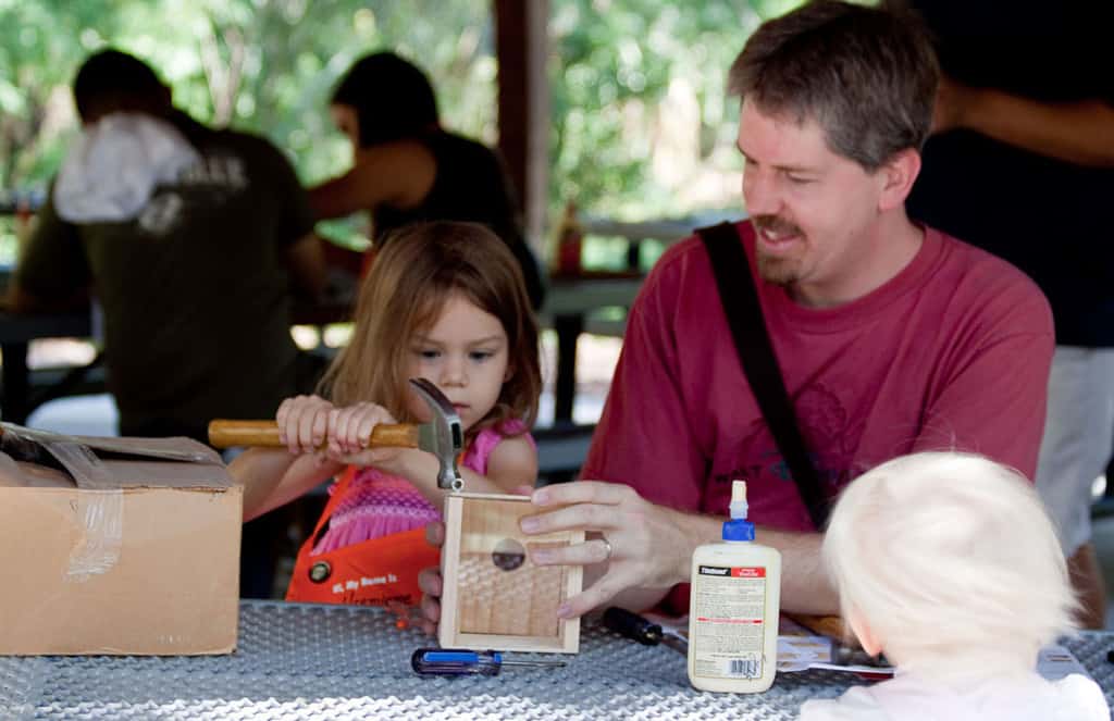 Dad using tools with daughters