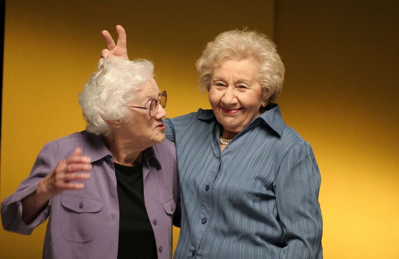 Elderly sisters making bunny ears