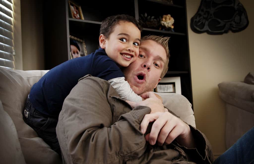 Toddler having fun wrestling father